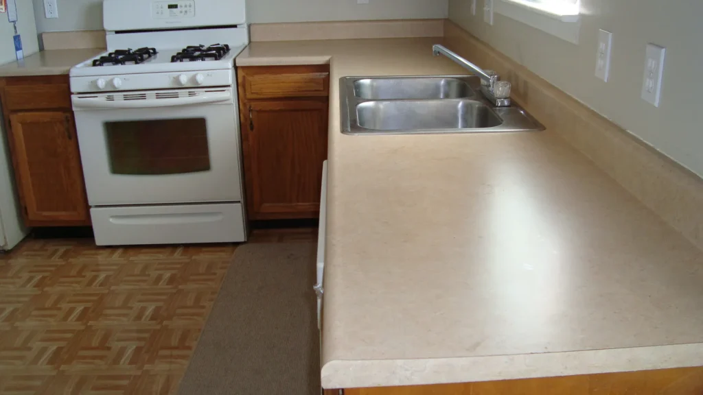 Existing kitchen countertop before replacement in Philadelphia — worn laminate surface with stainless steel sink and oak cabinets ready for a professional countertop upgrade.